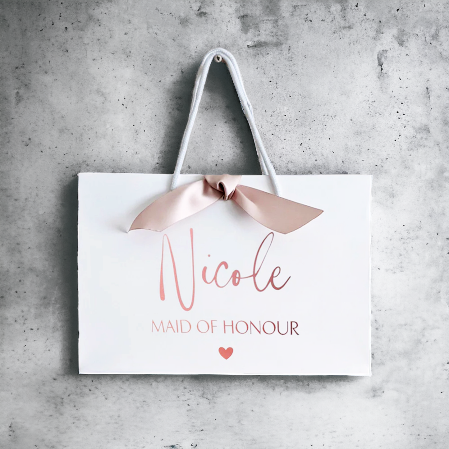 personalised bridesmaid gift bag rose gold with ribbon on wall