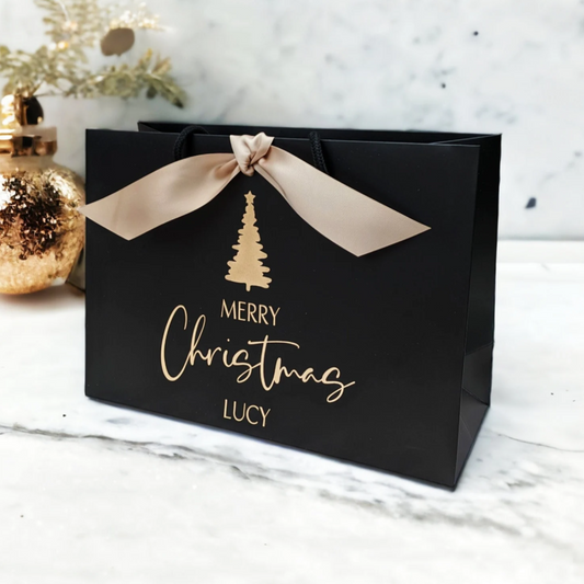 Personalised Christmas gift bag with name, black bag with gold ribbon, side view