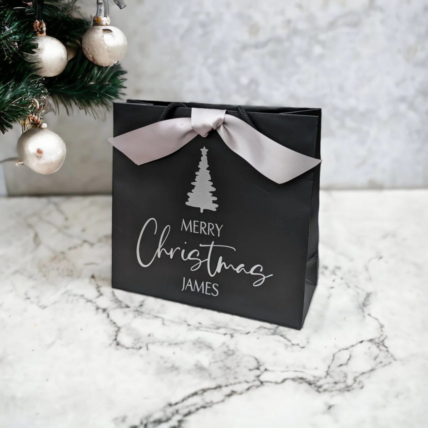 Personalised Christmas gift bag with name, black bag with silver ribbon, side view, size small