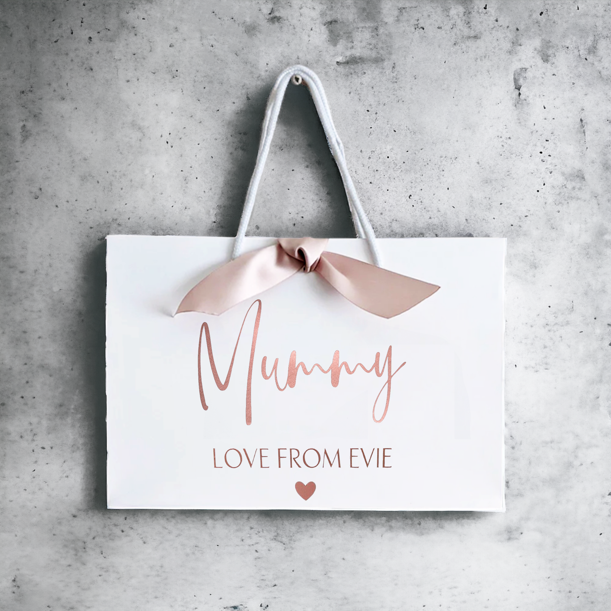 personalised mother's day rose gold gift bag with ribbon on a wall