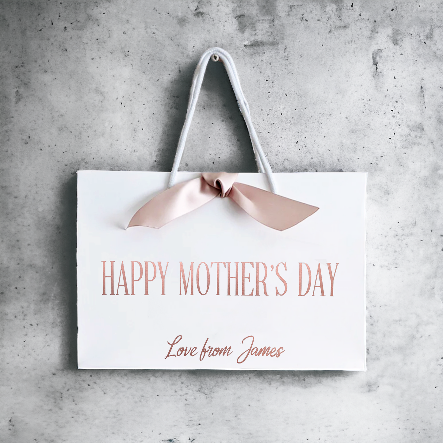 personalised mothers day gift bag rose gold with ribbon on a wall